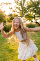 Obraz premium happy little girl with long hair is walking in the summer