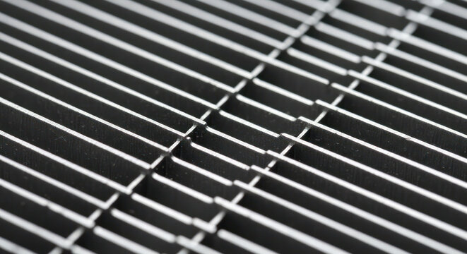Close-up of a metal grate with parallel bars on a white background