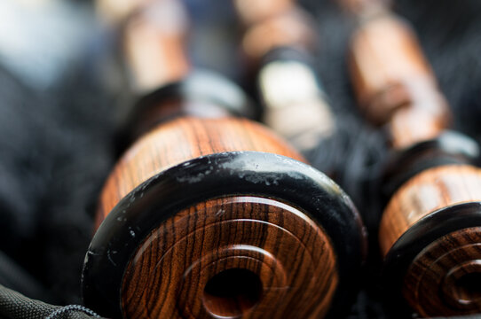 Close-up perspective of the circular wooden base and rings of a traditional wind instrument, highlighting texture and shine.