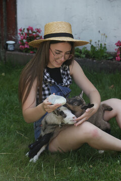 Young Woman With Baby Goats on Countryside Farm &ndash; Rural Lifestyle, Animal Care, Wellbeing and Slow Living Concept