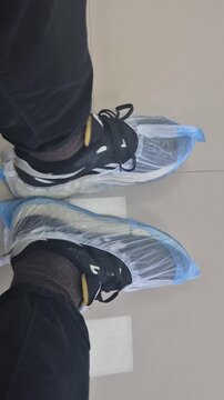 Close-up of shoe covers on the feet of a waiting man in a hospital