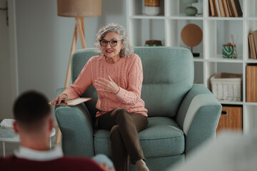 Obraz premium Senior woman psychologist consulting patient in therapy session
