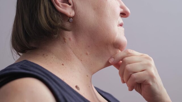 Elderly woman with double chin on isolated background