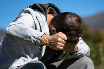 Person sitting with head in hands showing emotional distress and mental pressure, symbolizing anxiety, psychological stress, burnout, and difficult life situation.