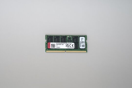 DDR5 ECC RAM Memory Module for AI and data centerson White Background. Close-up of a green DDR5 ECC RAM stick with white label, gold contacts, and black chips against a neutral gray background.