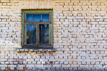 Old Window on Weathered Brick Wall. A rustic old window set in a worn brick wall, showing aged texture, peeling paint, and vintage architectural character.