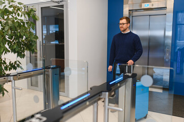 Business traveler passing through turnstile at office lobby
