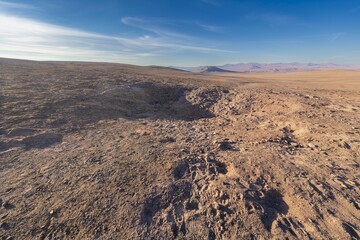 Vaca Muerta Meteorite Impact Crater in Atacama Desert, Chile. A wide-angle view of the Vaca Muerta meteorite impact crater in the arid landscape of the Atacama Desert, Chile, under a clear blue sky © abriendomundo