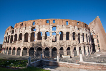 Naklejka premium Colosseum in Rome under a bright blue sky.