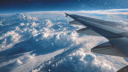 Obraz premium Plane wing shows clouds below as earth and sky pass by.