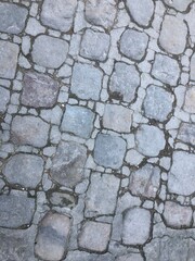 Obraz premium Weathered grey cobblestones concrete pavement surface cracks stone borders texture aged slabs
