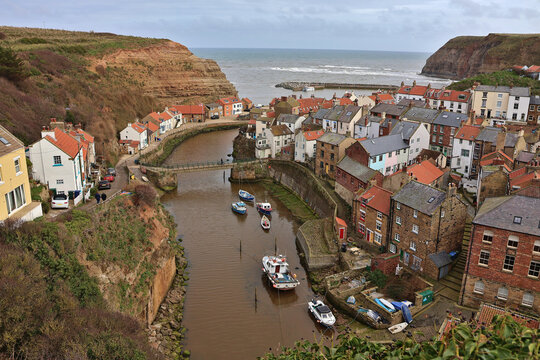 View of Staithes village, North Yorkshire, England; Staithes Beck and Cowbar Nab viewed from above, scenic coastal fishing village, traditional cottages and buildings, North Sea harbour, UK