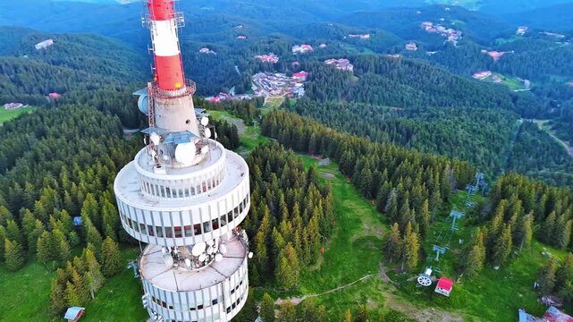 Tower Snezhana on peak of Snezhana covered with spruce forests in Rhodope mountains
