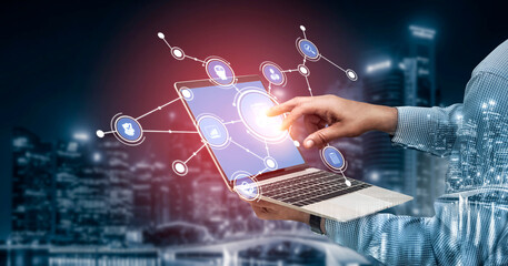 A hand interacts with a digital laptop interface, highlighting technology and innovation against a...