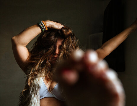 Woman with hand in her hair and foot in front of lens