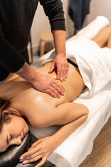 Masseuse providing back massage for woman in spa