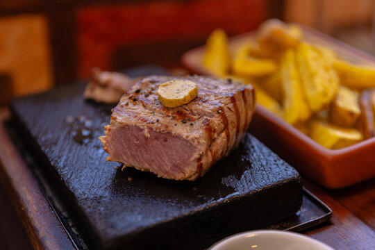 High-resolution photograph of alpaca tenderloin served with roasted native potato strips on a plate in Arequipa. This traditional Andean dish highlights the unique flavors of Peruvian highland cuisine