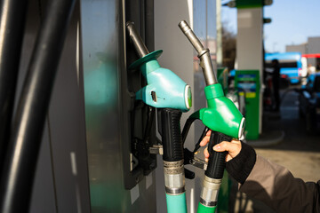 Hand holding gasoline pump nozzle at fuel station © Rabizo Anatolii