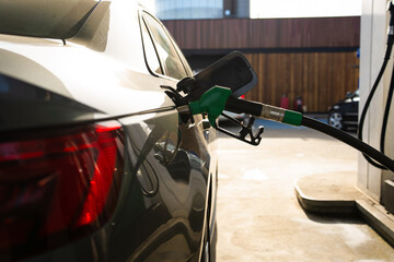 Refueling vehicle with hand on gasoline pump nozzle © Rabizo Anatolii