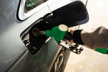Fuel nozzle dispensing petrol into vehicle tank © Rabizo Anatolii