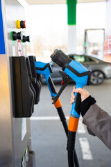 Hand gripping LPG dispenser nozzle while refueling vehicle © Rabizo Anatolii