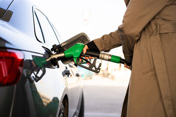 Fuel pump inserted into tank during refueling. Close-up of hand refilling vehicle with gasoline © Rabizo Anatolii