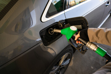 Fuel pump inserted into tank during refueling. Close-up of hand refilling vehicle with gasoline © Rabizo Anatolii