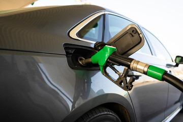 Close-up refilling vehicle with gasoline. Fuel pump inserted into tank during refueling © Rabizo Anatolii