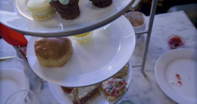 Smooth steady cam high shot dropping down on tower of plates with snacks on table