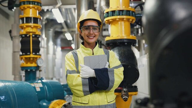 A woman, perform maintenance on a water tower and pipeline system, focusing on cooling and safety in a construction site.

