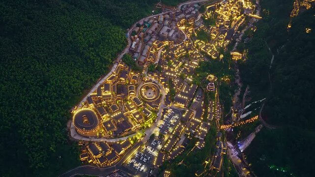 Night view of Wangxiangu resort with traditional illuminated architecture and mountain landscape in Jiangxi, China.