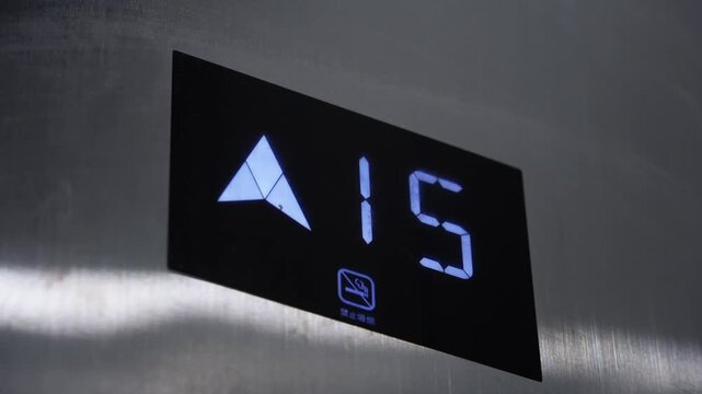 Elevator floor indicator panel showing level 17 with upward arrow and blue LED illumination