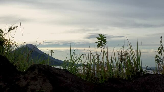 Mount Batur, Bali, Indonesia &ndash; Monkey Running Across Summit with Vegetation and Mount Abang in the Distance