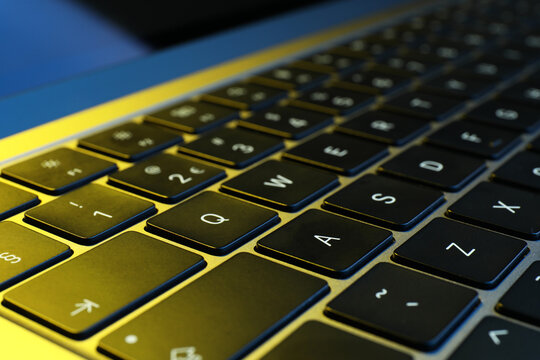 Stylish modern laptop in neon lights, closeup