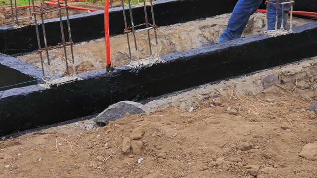 Waterproofing, detail of foundation beams and steel reinforcement with moisture-insulating coating