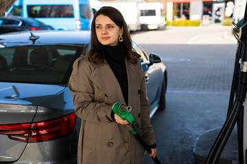 Fuel pump inserted into tank during refueling. Close-up of hand refilling vehicle with gasoline © Rabizo Anatolii