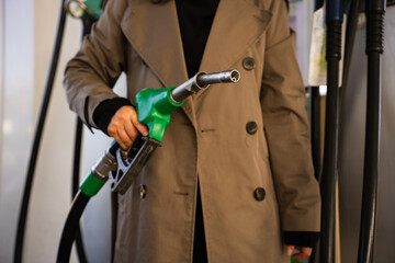 Woman holding gasoline nozzle while refueling car at petrol station © Rabizo Anatolii