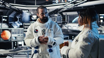 Fototapeta premium Astronauts discussing last details stepping out for scheduled operations outside starship exploring deep space. Cosmonauts chatting, preparing for mission launch after landing on planet