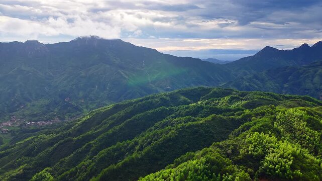 Majestic green mountain ranges and dense forests under dramatic cloudy sky in Jiangxi China.