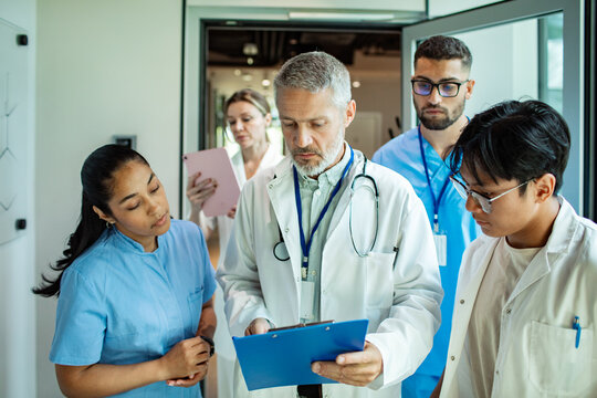 Medical team discussing patient case in hospital corridor
