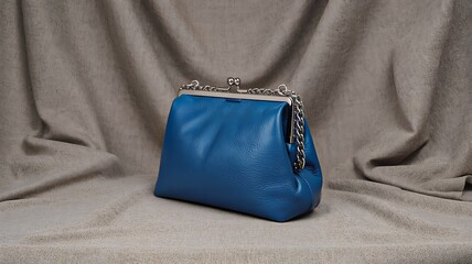 Naklejka premium Elegant blue leather handbag with metal clasp on fabric background fashion accessory concept