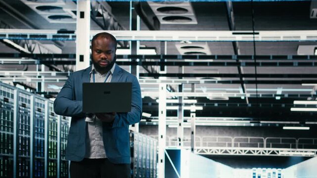 Server farm developers using laptop to optimize electronics. Data center teamworking coworkers brainstorming, using notebook device to monitor system performance bottlenecks