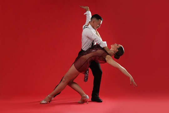 Couple of professional dancers on red background
