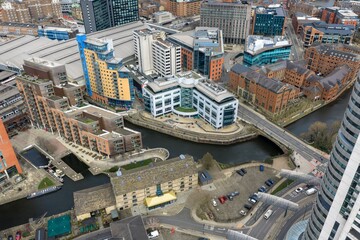 Fototapeta premium Drone aerial view of Royal Armouries Museum and Leeds Dock waterfront with River Aire modern offices apartments bridges and roads beneath cloudy sky