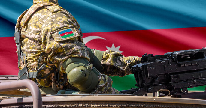 Azerbaijan national flag with soldier at machine gun turret in front of it. Closeup side view.