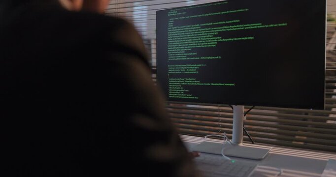 Programmer developer man coding computer monitor workplace. Focused coder programming in a corporate office, building reliable software with clean code. Clear concept of modern productivity.