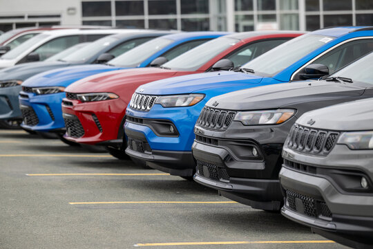 Newfoundland, Canada - March 20, 2026: A row of new blue, black, grey, and red Jeep utility vehicles in the parking lot of a car dealership. The modern vehicles are electric rechargeable automobiles.