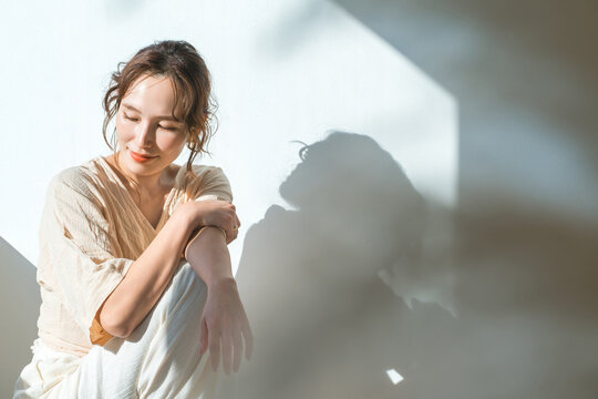 A woman by the window in the setting sun (model, fashion, light, shadow)