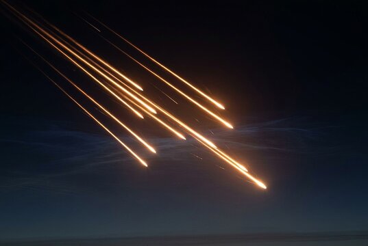 Cluster of luminous re-entry vehicle trails descending through a dark pre-dawn atmosphere in parallel formation. For nuclear deterrence, defense, geopolitics, and editorial security themes.