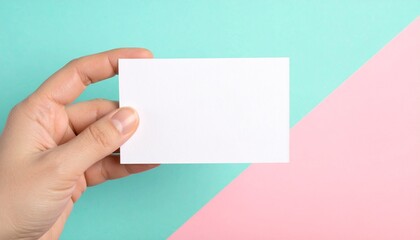 Obraz premium Hand holding blank white card on stylish pastel colored background.